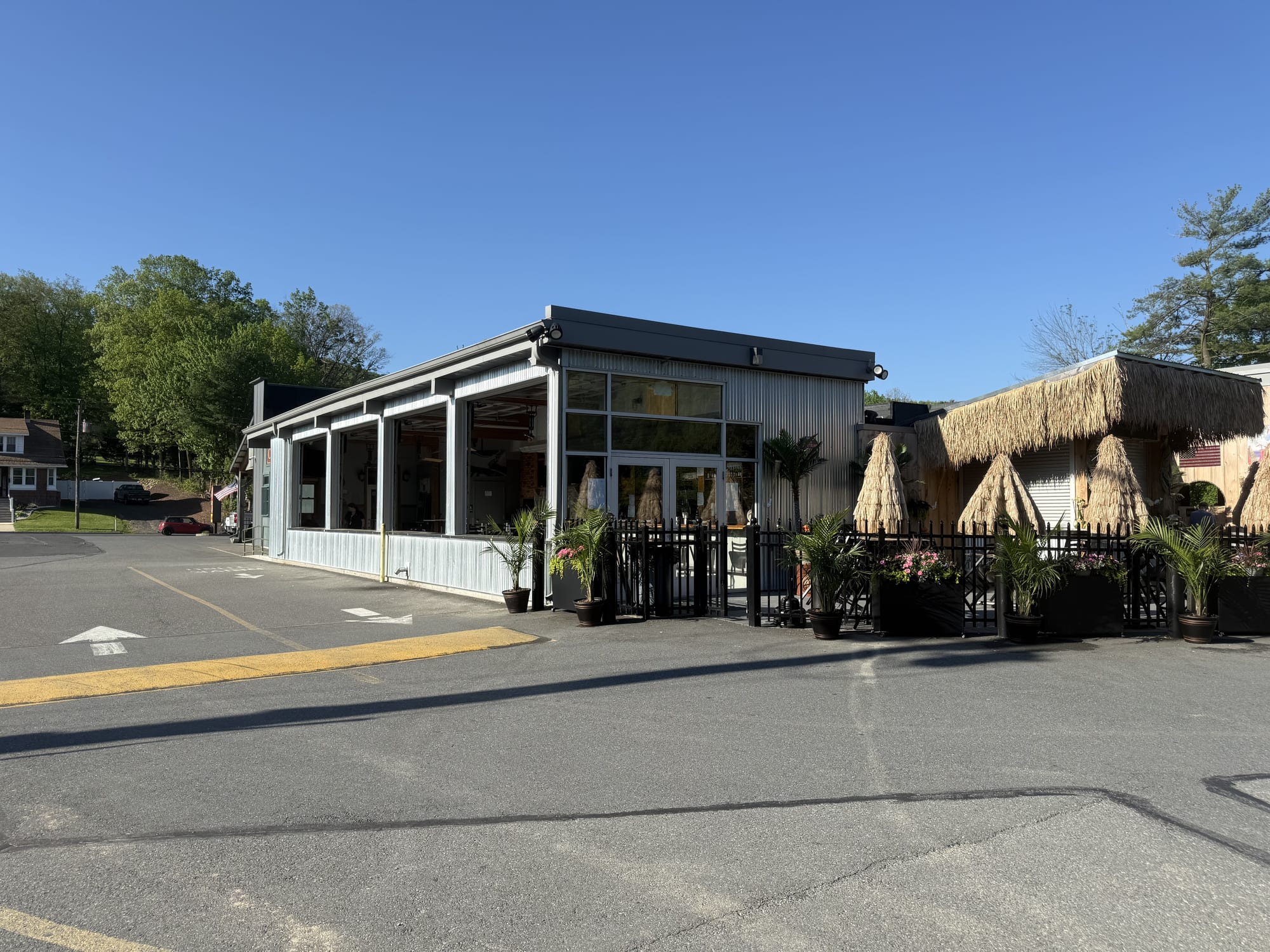 The Coney Island in Pottsville, PA, from the side — the four-season patio along the right of the building and the seasonal tiki bar's thatched roofs around back.
