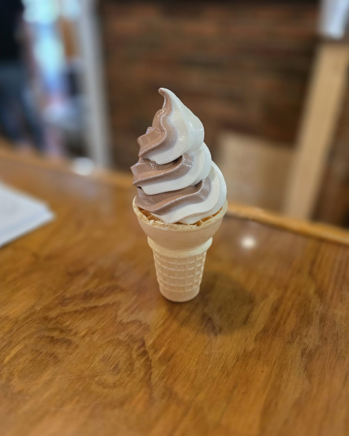 A chocolate-and-vanilla soft-serve twist cone standing on the wood counter at The Coney Island in Pottsville, PA.